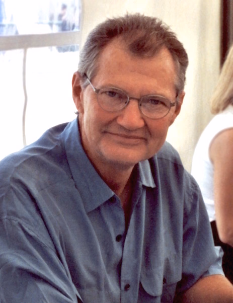 Andrew Robinson mit Brille und blauem Hemd bei einer Veranstaltung