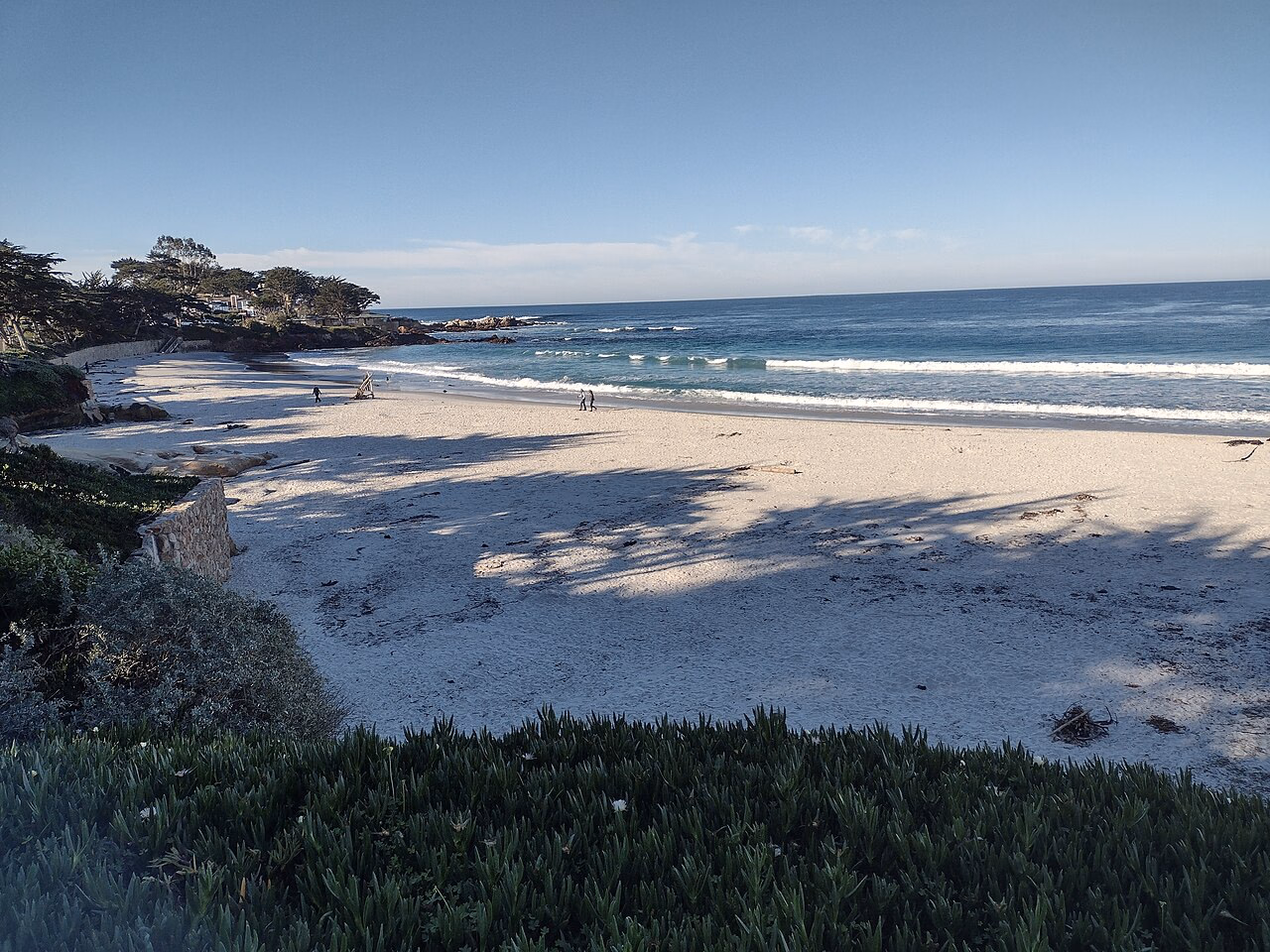 Wellen an einem weiten Sandstrand in Carmel an der kalifornischen Küste