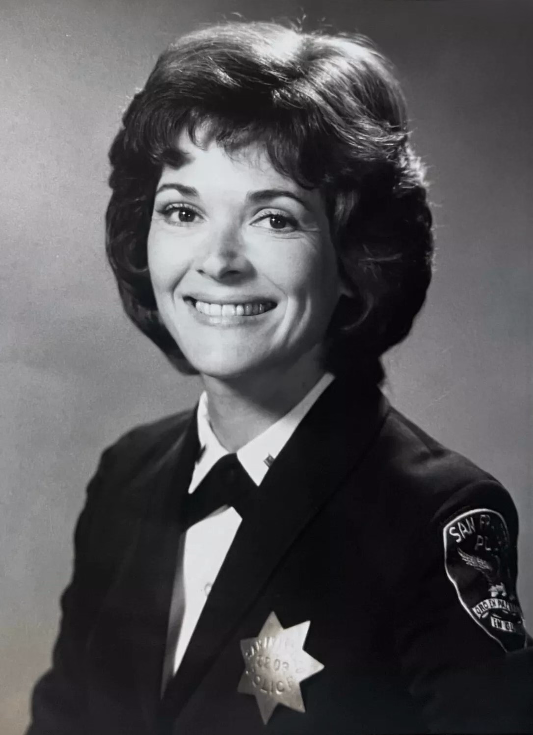 Jessica Walter lächelt auf einer Schwarzweißaufnahme in Uniform